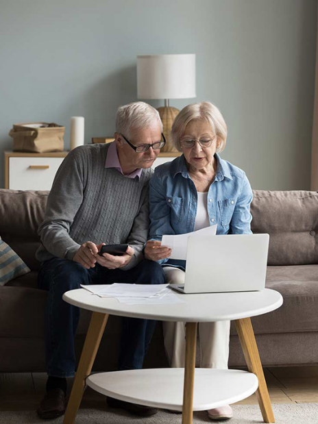 Seniors reading on laptop