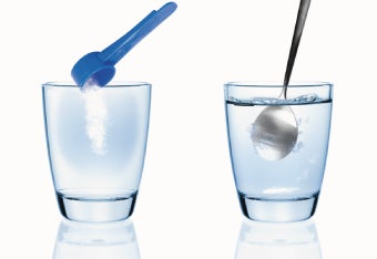 Zwei Gläser mit Wasser und einem Löffel Pulver, das eingerührt wird.
