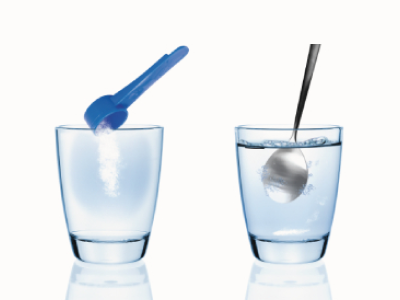 Zwei Gläser mit Löffeln und Wasser, eines mit Pulver.