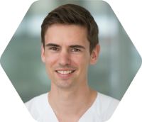 Ein Mann mit braunen Haaren trägt ein weißes Hemd.