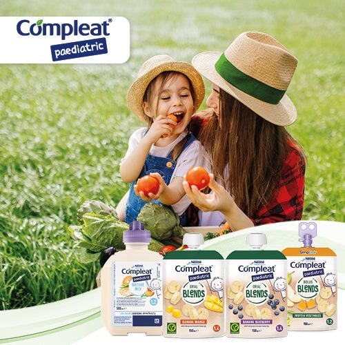 Mutter und Kind auf einer Wiese mit Gemüse, darunter „Compleat Paediatric“-Produkte.