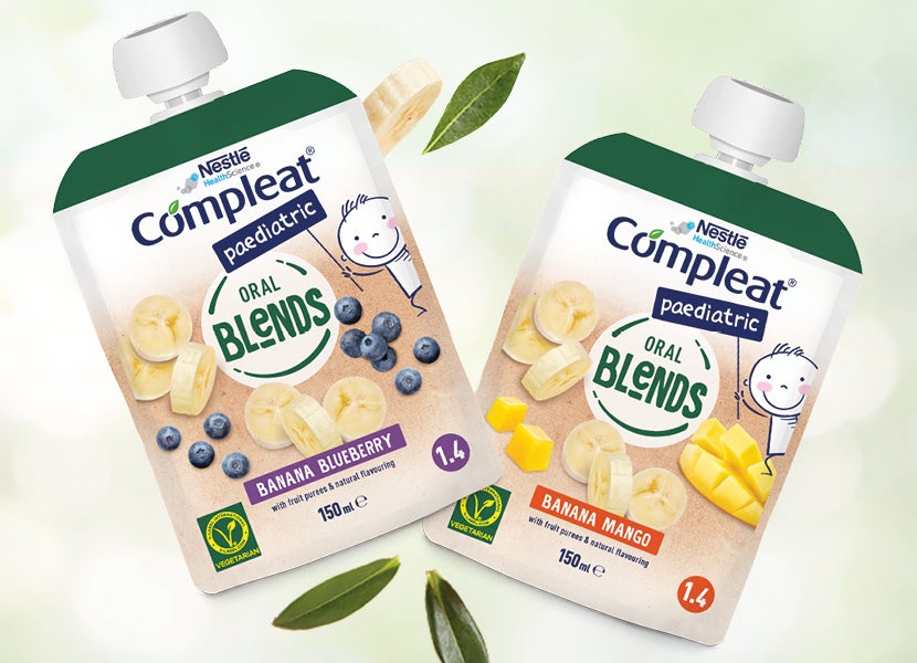 Zwei „Compleat Paediatric Oral Blends“-Beutel in den Sorten Banane-Blaubeere und Banane-Mango.