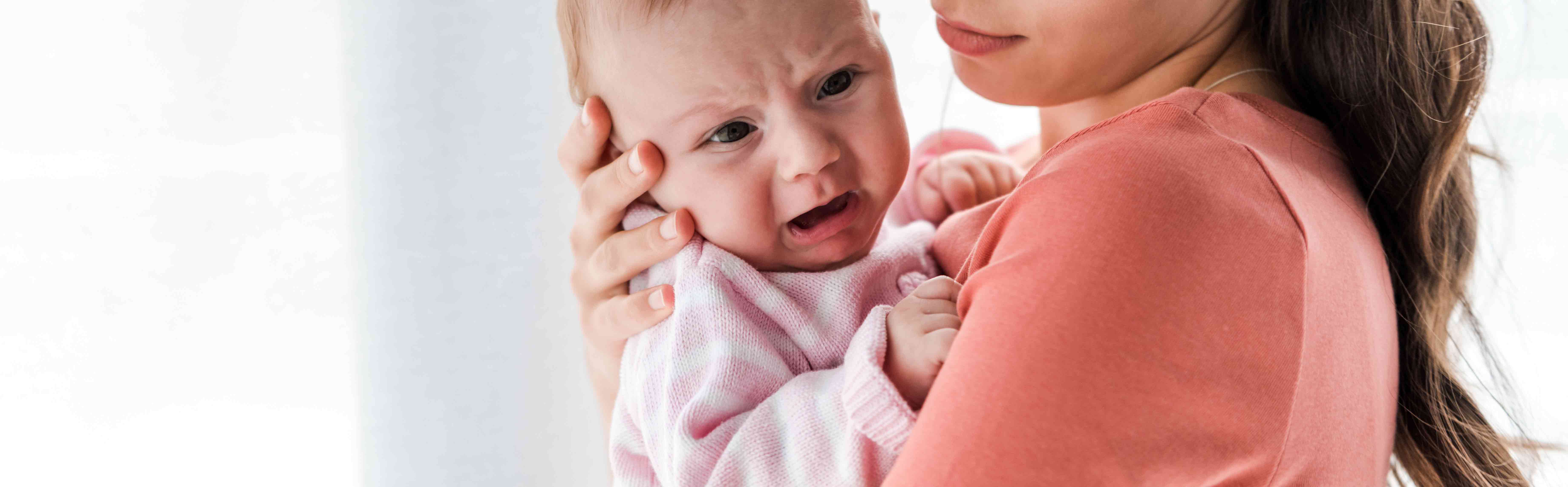 mother holding crying infant