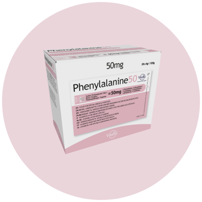 Schachtel mit Phenylalanin-Tabletten, 50 mg, rosa Hintergrund