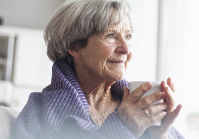 old woman holds a cup