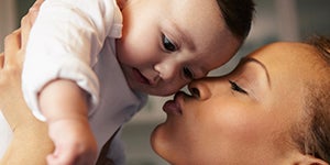 mom kissing her happy baby